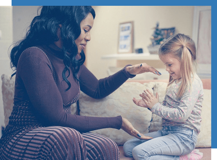 A woman and child playing with something in their hands.