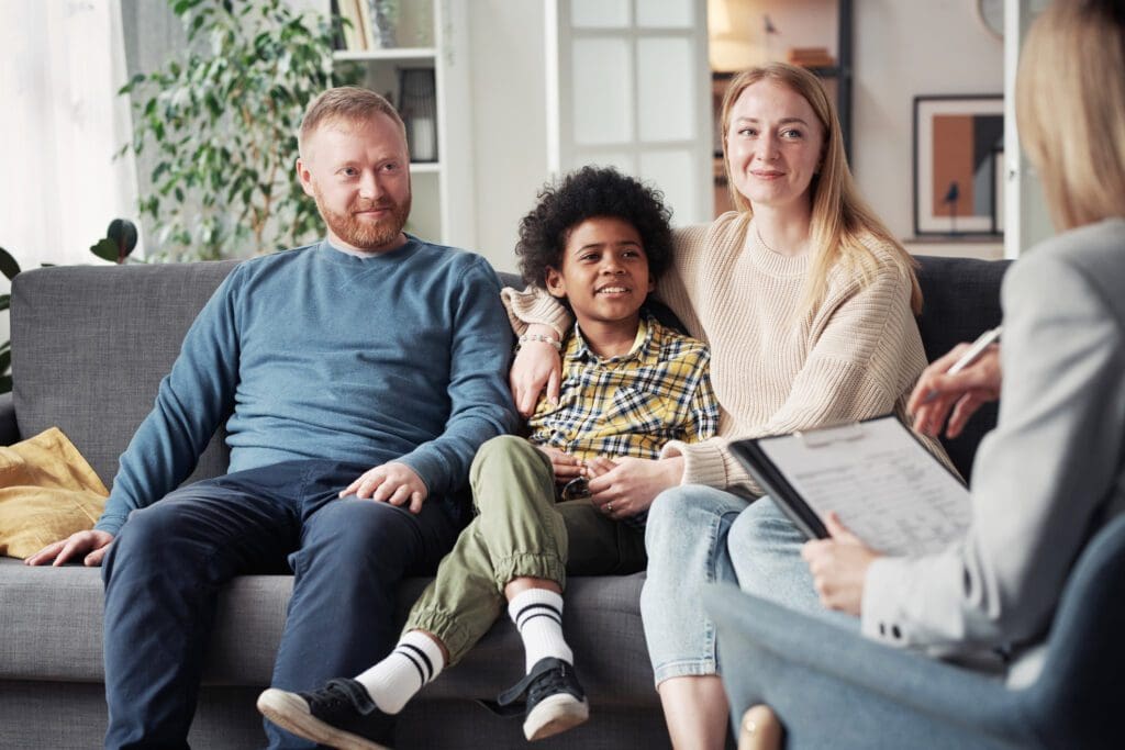 A family sitting on the couch together with one child