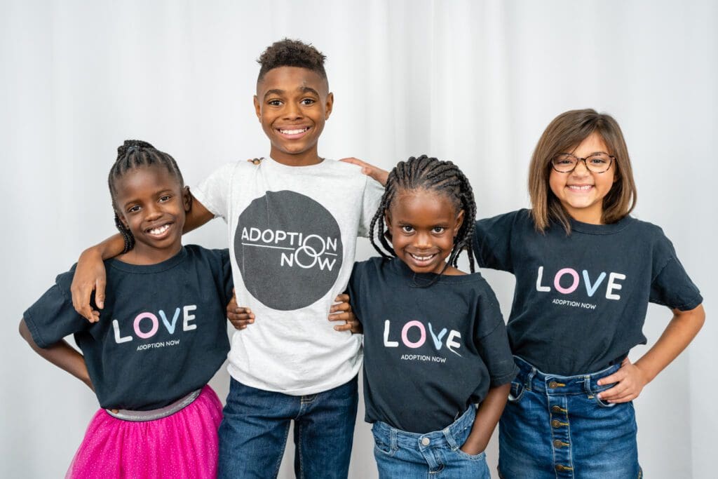 A group of kids wearing black shirts and smiling.