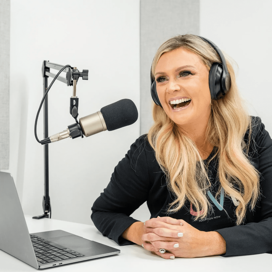 A woman with headphones on sitting in front of a laptop.